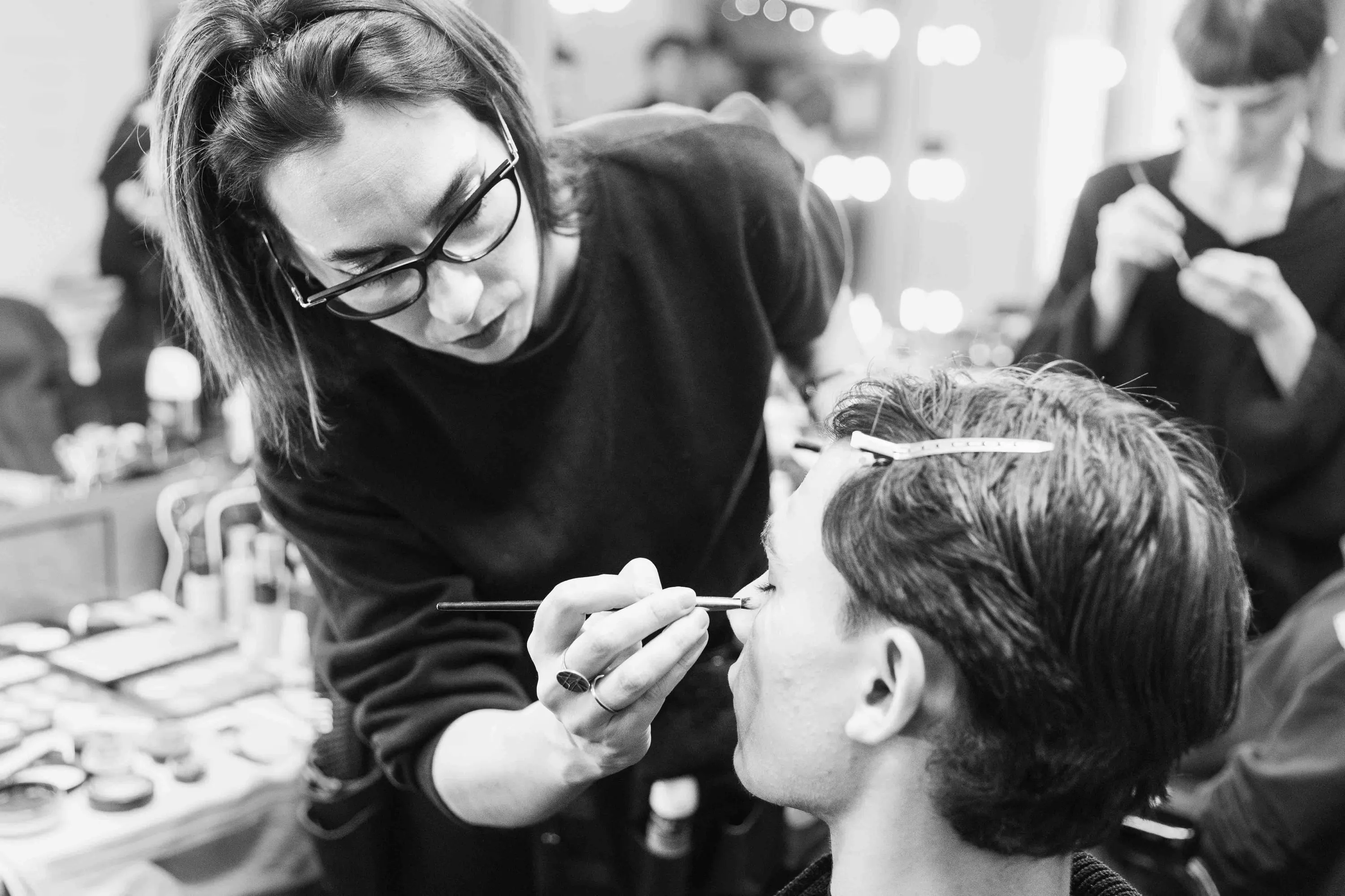 A make-up artist makes up a young dancer's face