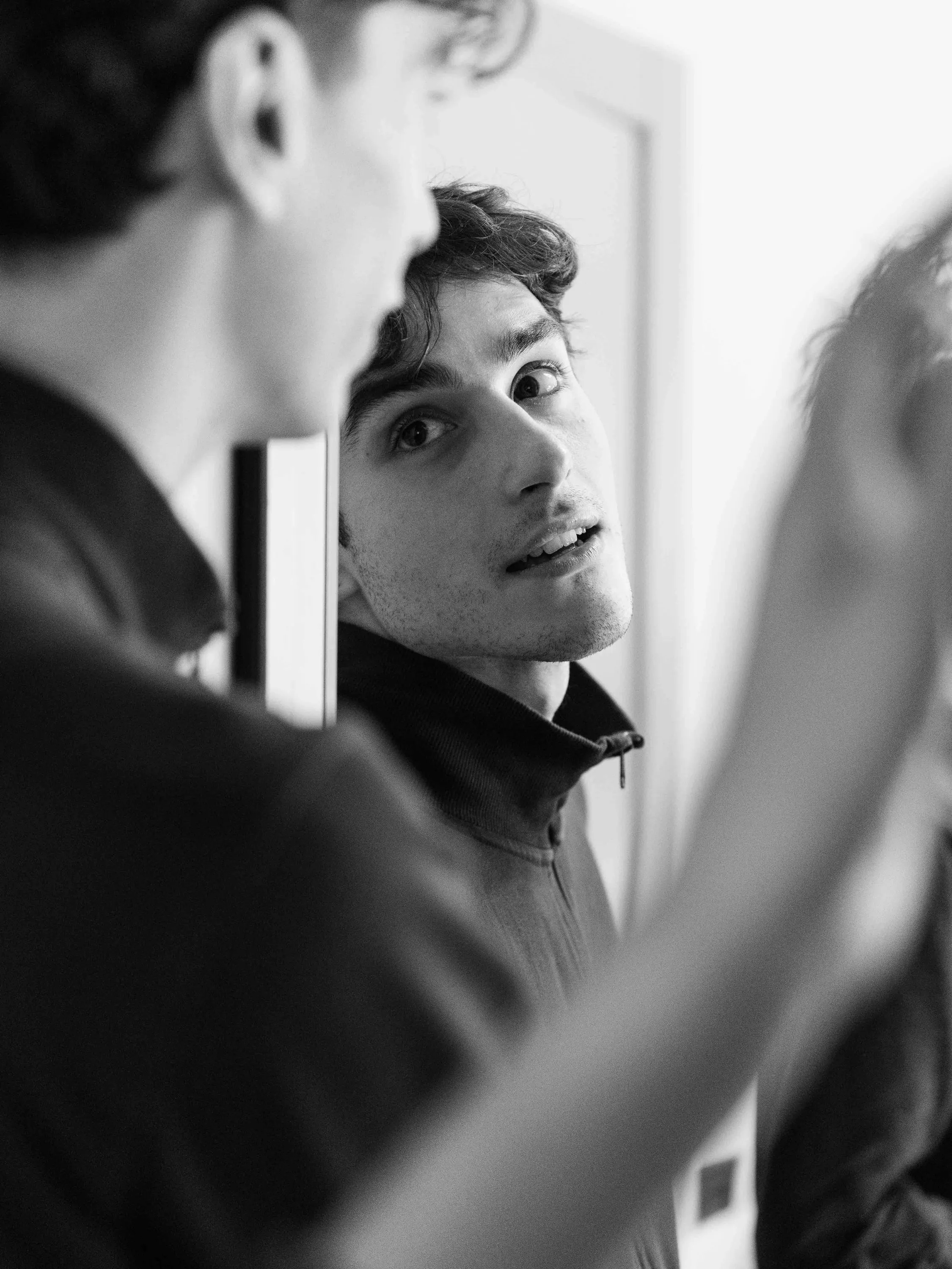 A dancer looks at himself in the dressing room mirror