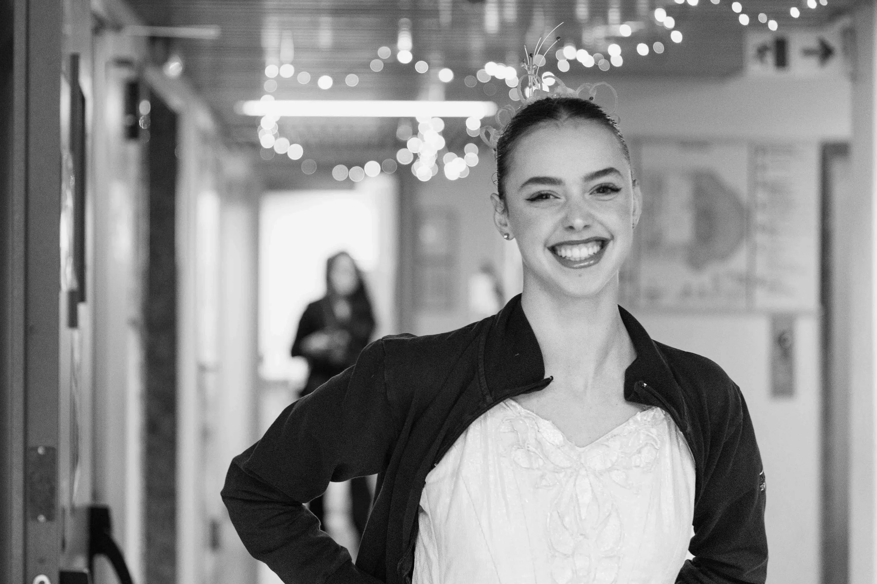 A smiling ballerina in the dressing room corridor