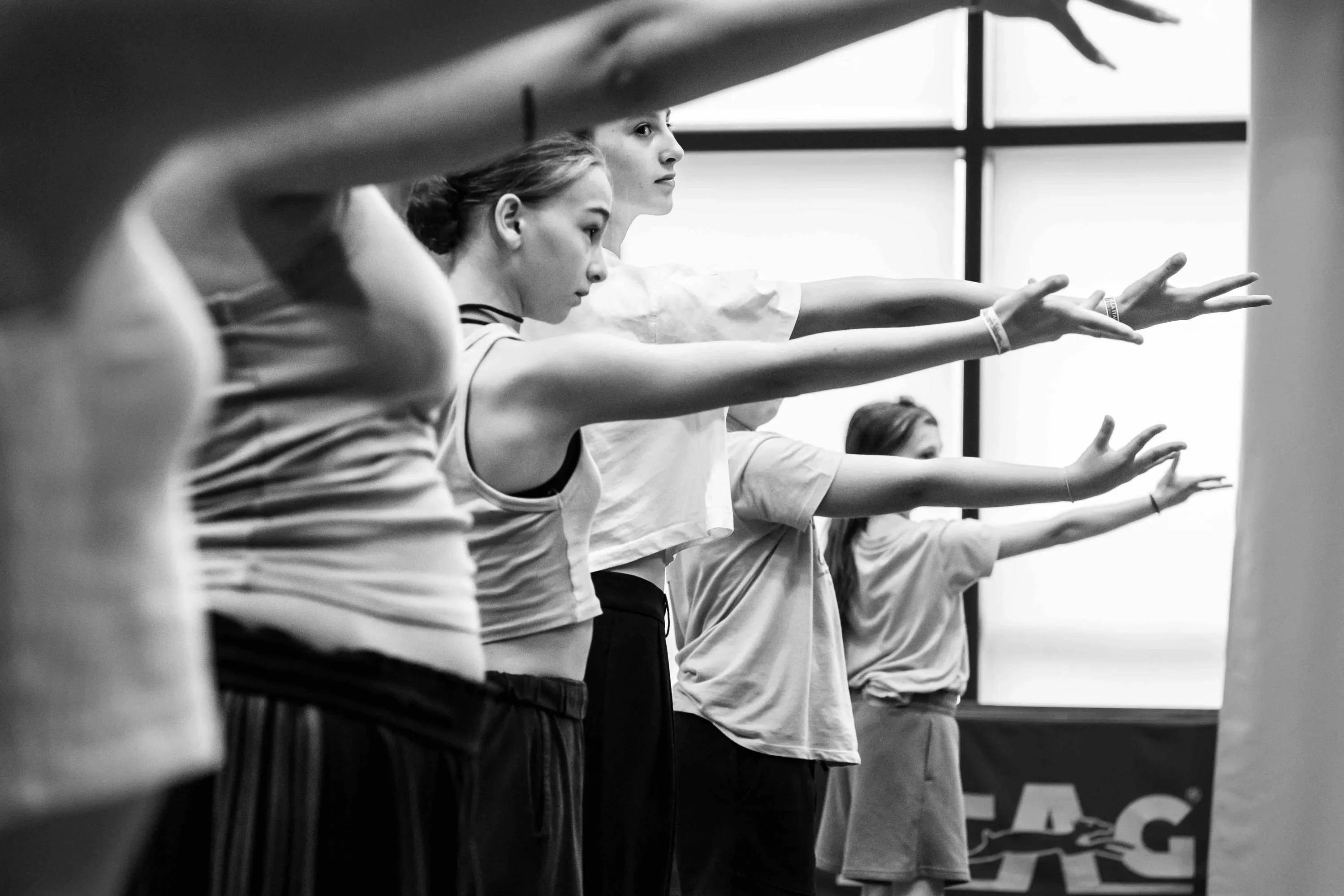 Students in a line with arms stretched forward