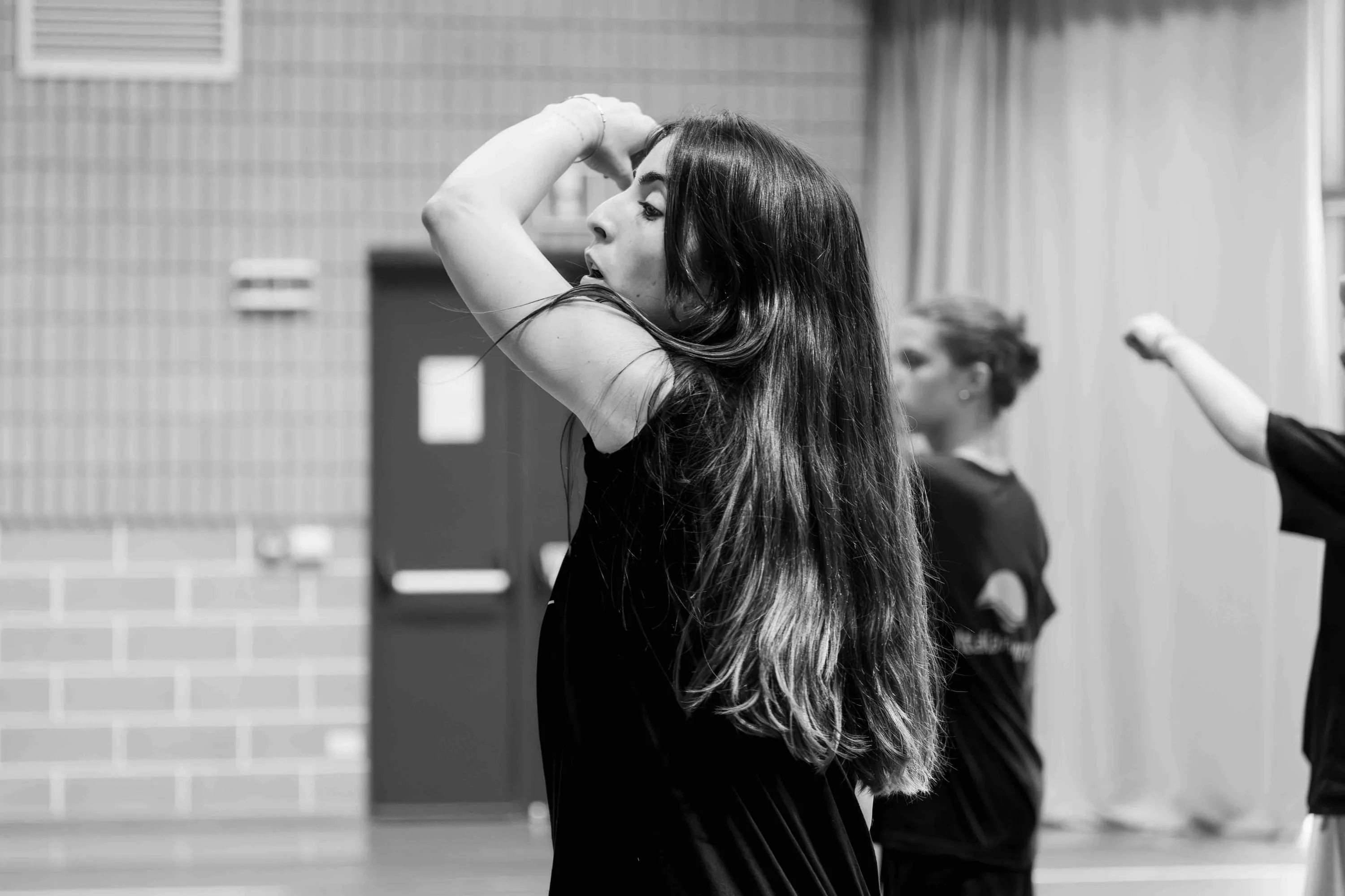 A student fixing her hair with one arm raised