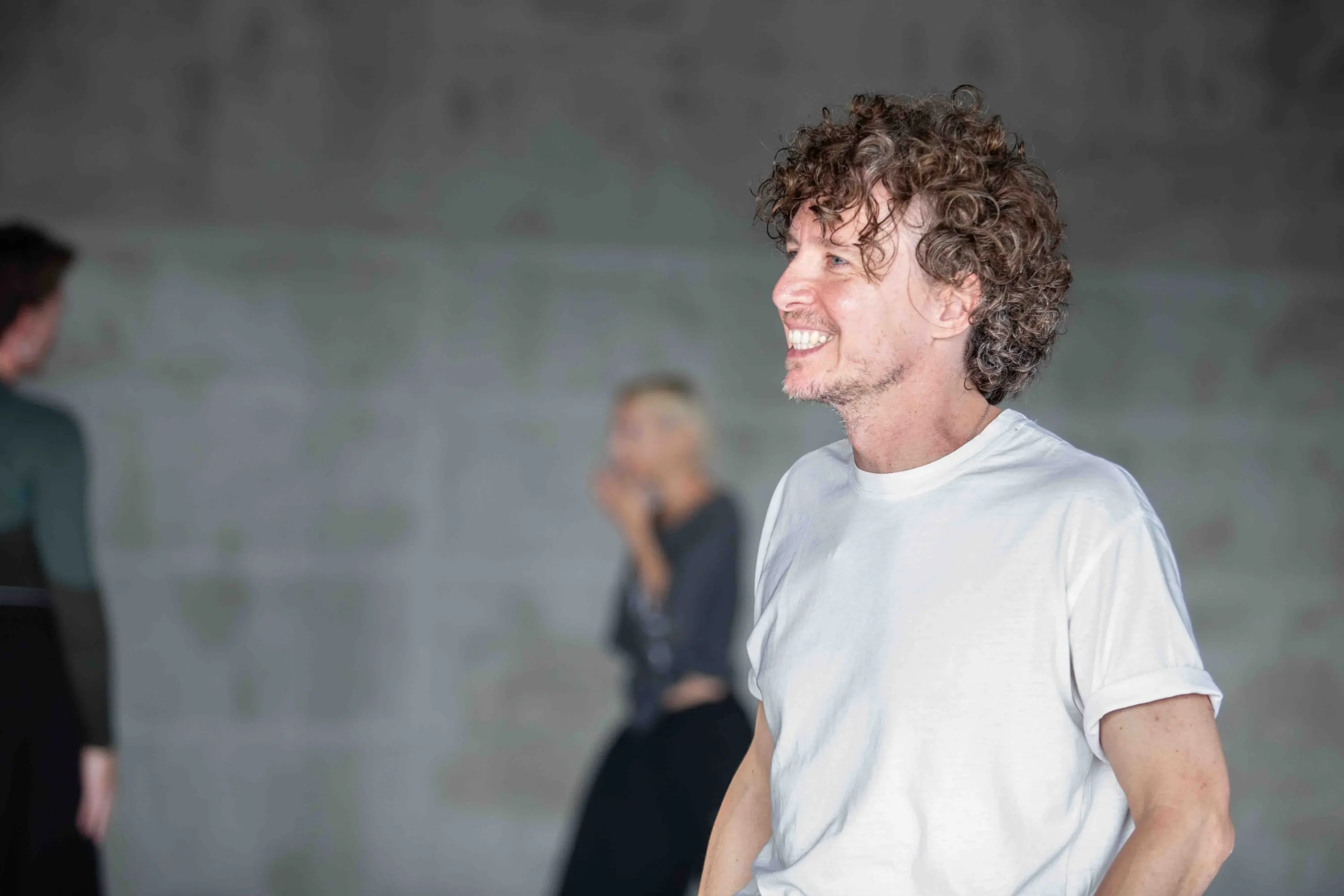 A choreographer smiles in the rehearsal studio