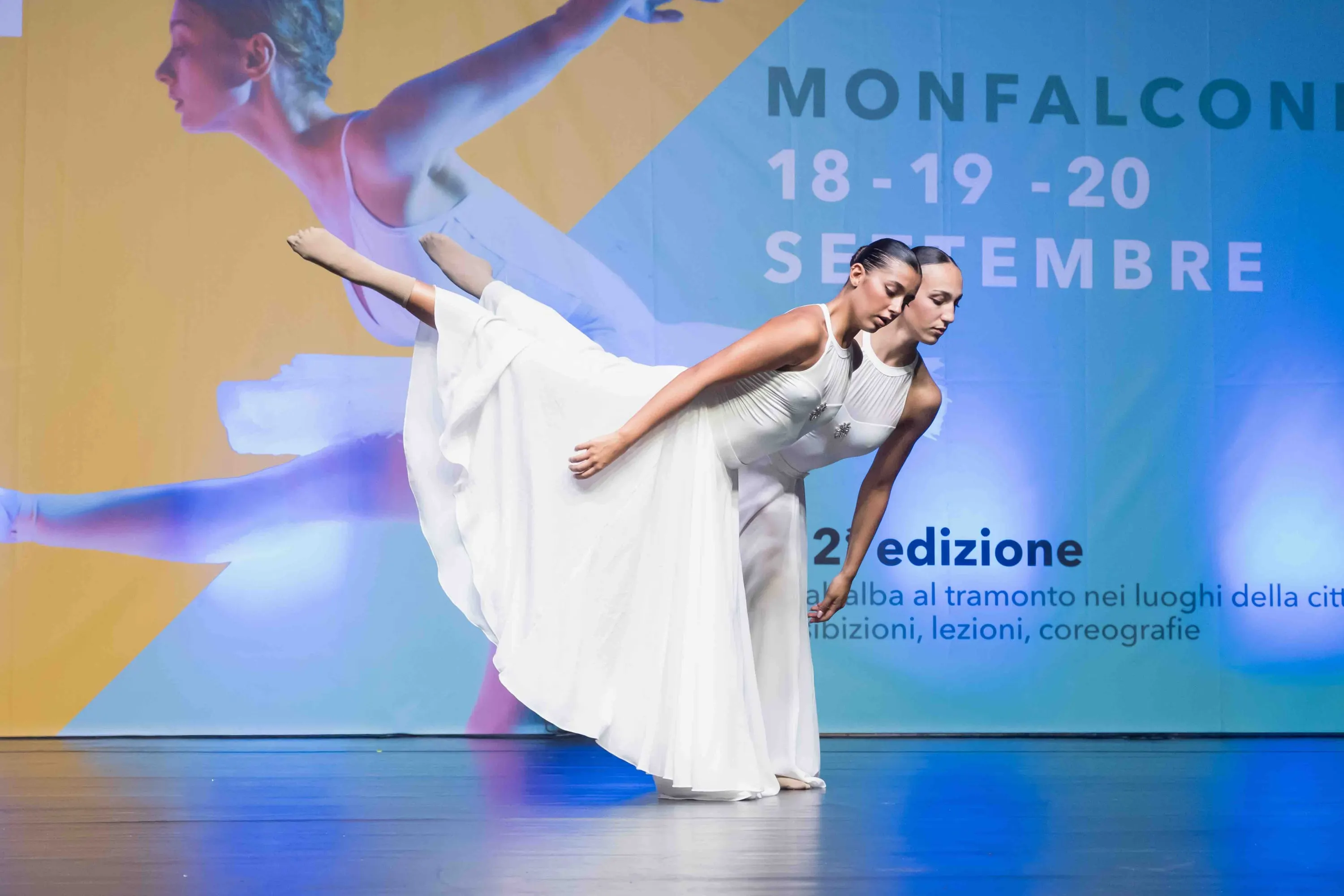 A dancer in a white dress in arabesque