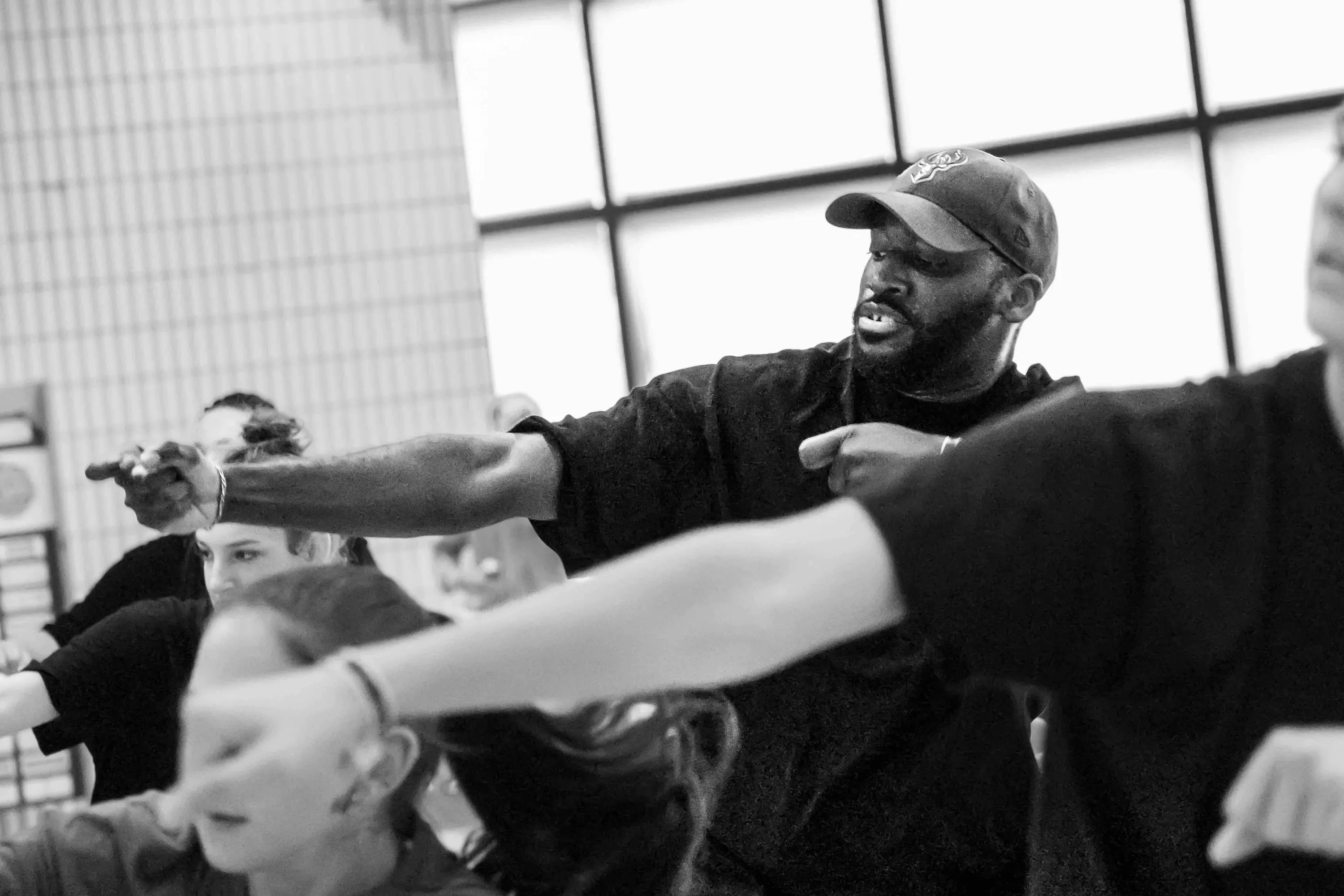The teacher in a cap stretches an arm among the students