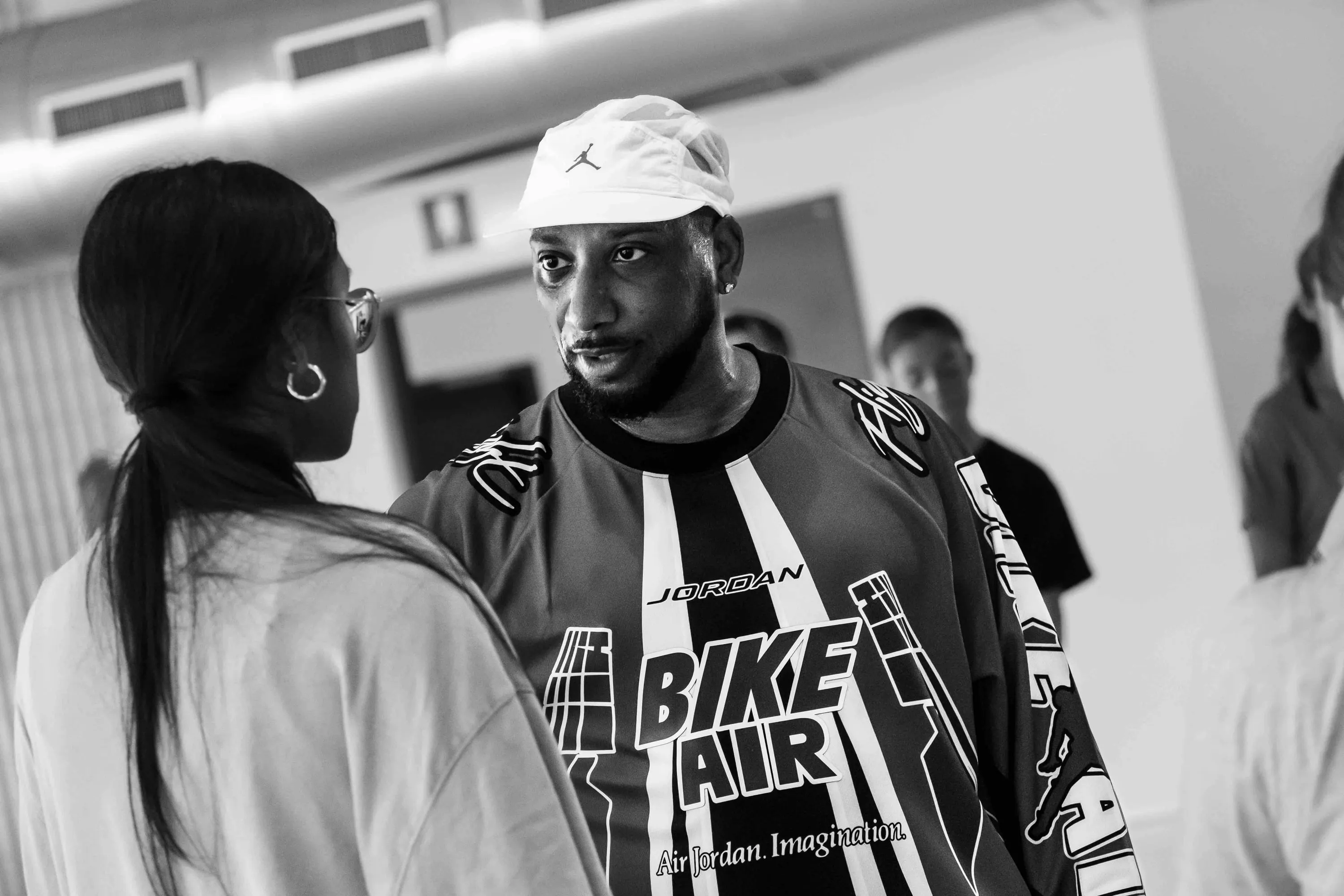 The teacher in a white cap talks with a student