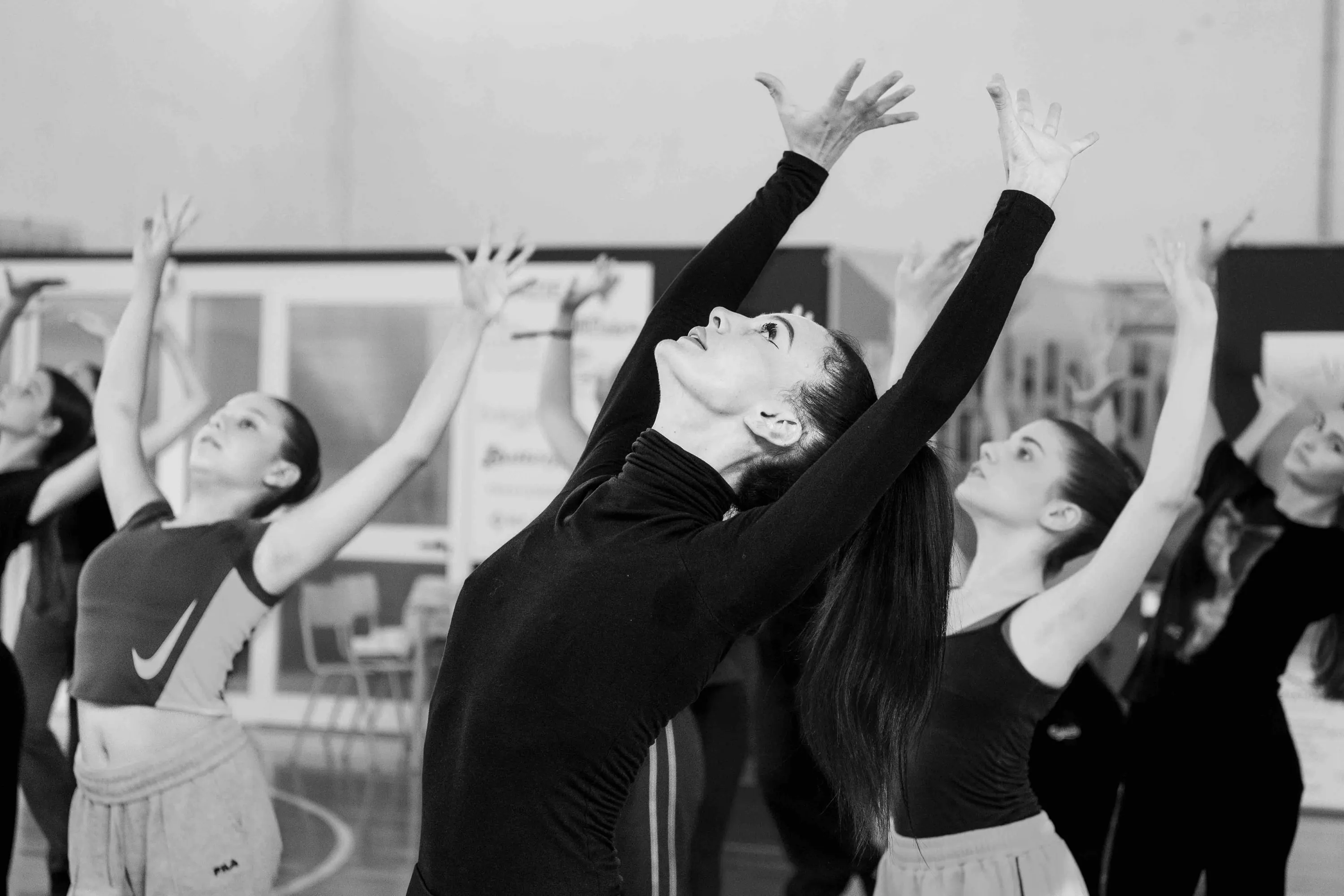 The teacher and students with arms raised, leaning back