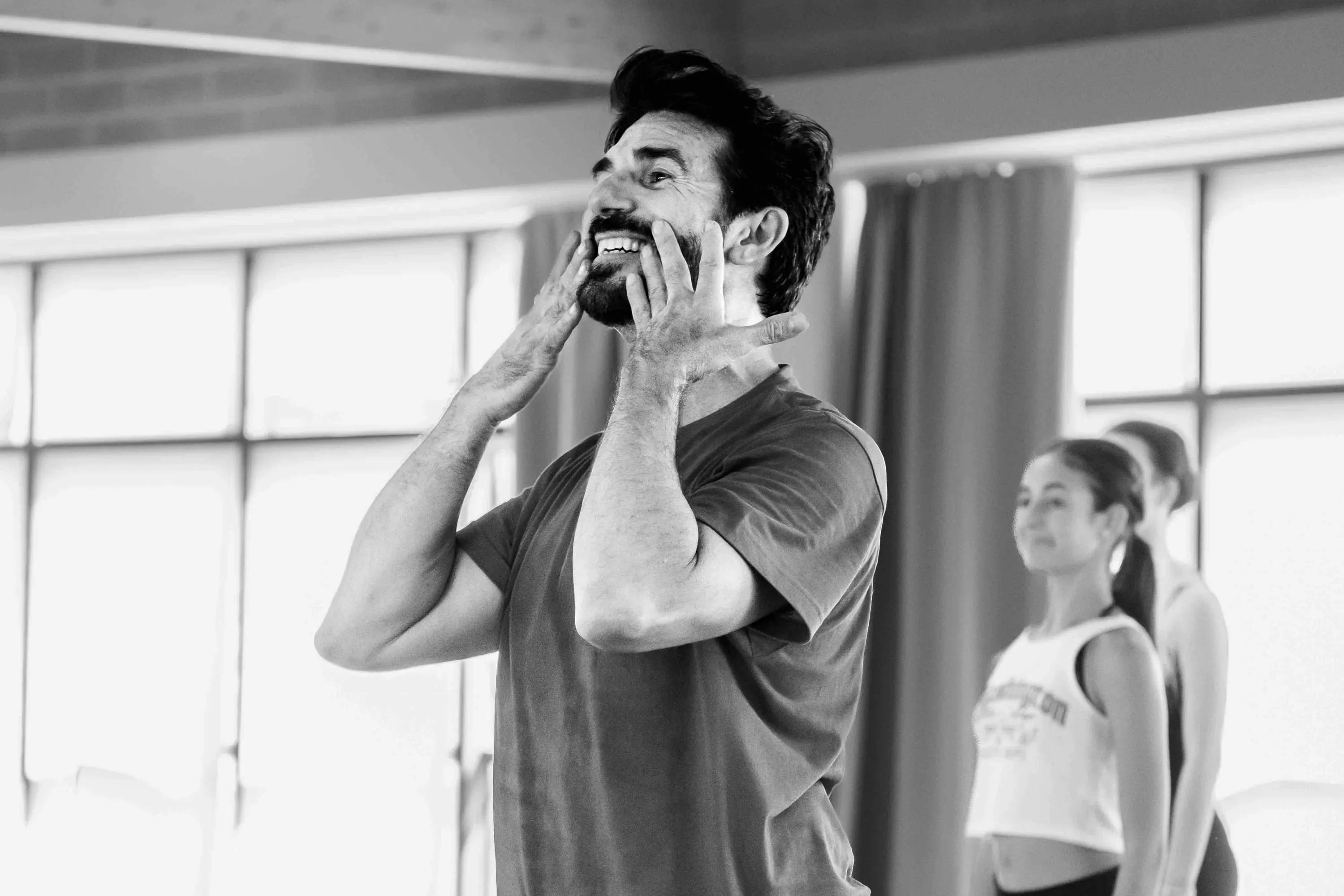 The teacher, hands to his face, expressive during class