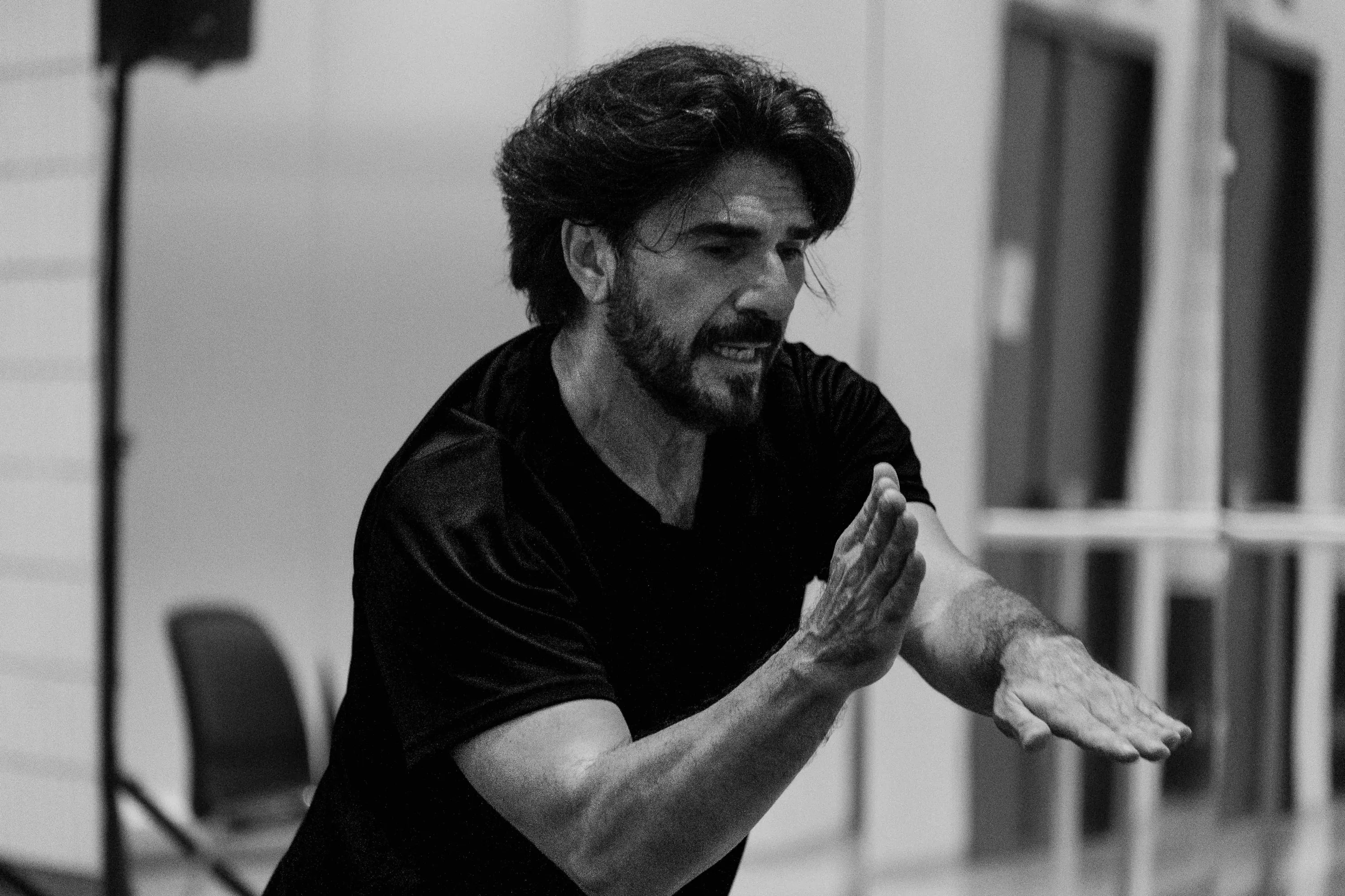 The teacher leans forward explaining a movement