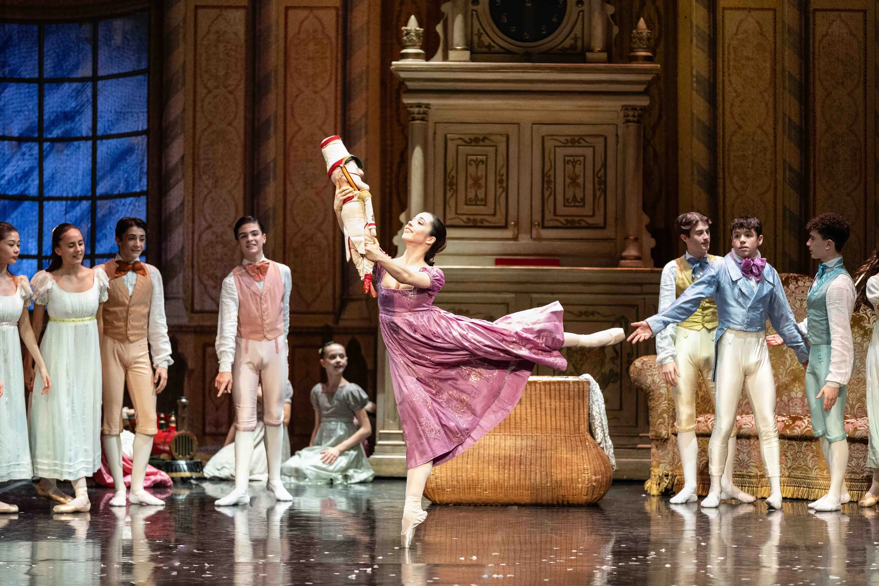 The party scene: a ballerina in pink in arabesque among the guests
