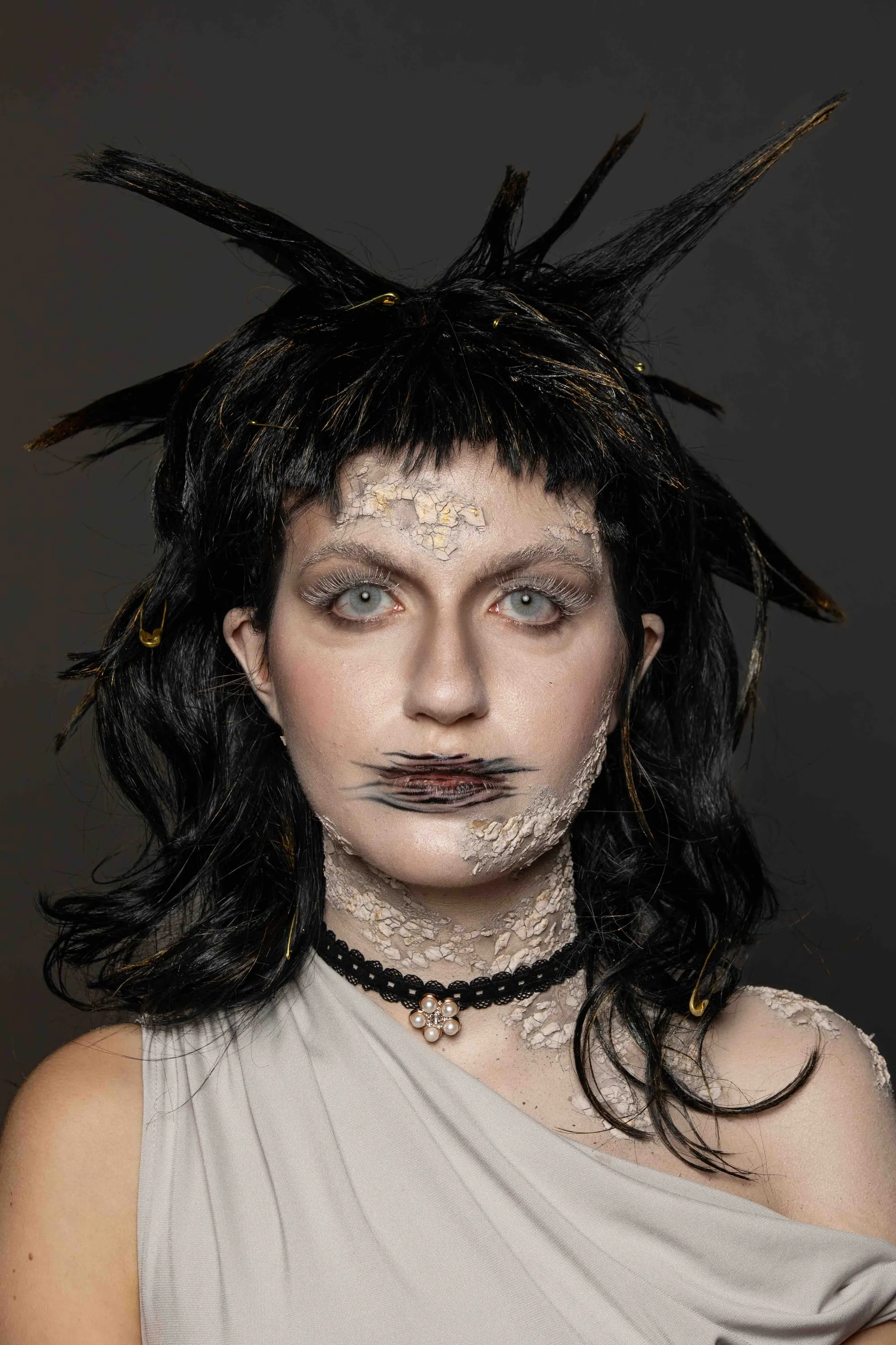 Theatrical make-up with a black feathered wig and stitched lips
