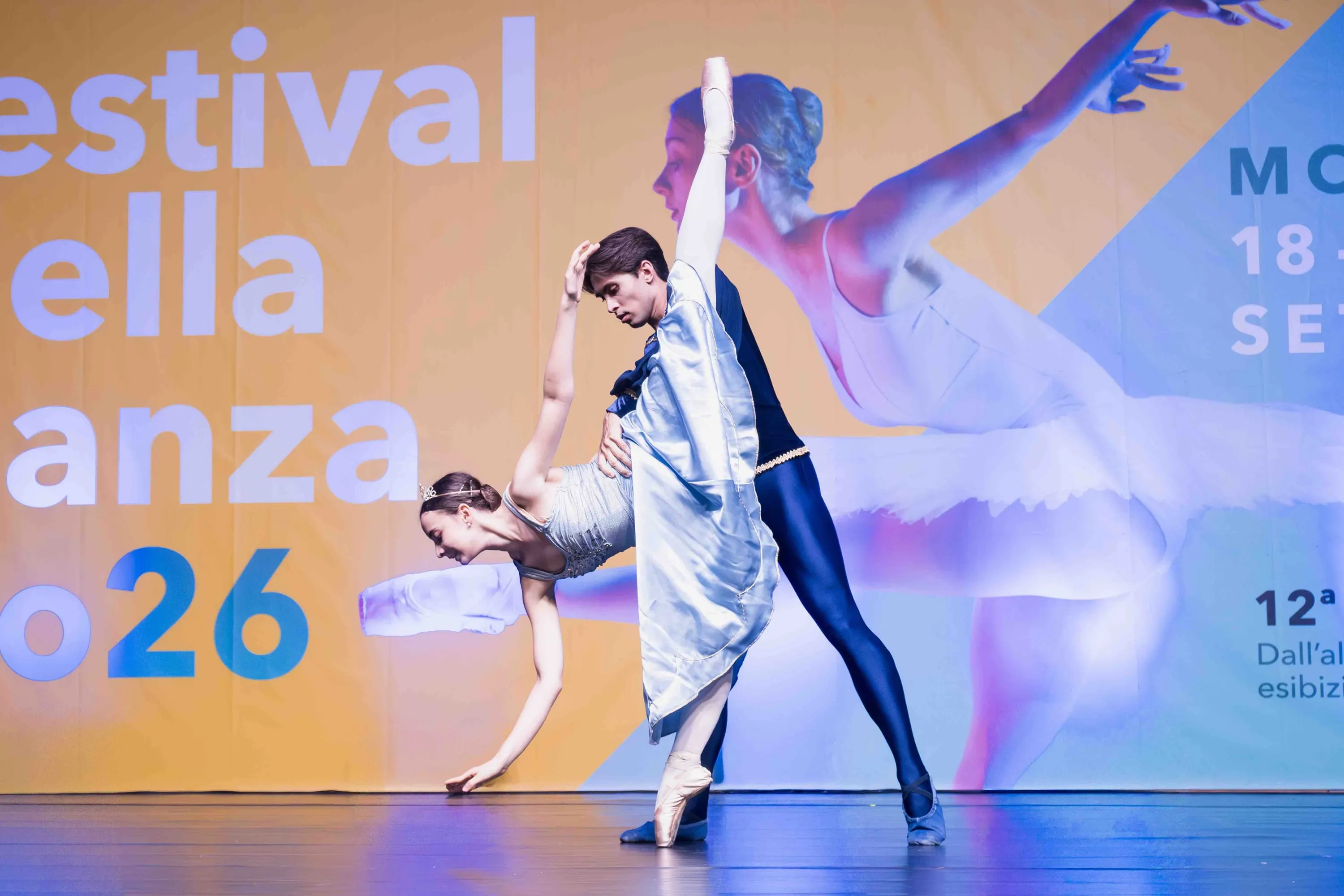 A dancer guides his partner into a deep backbend