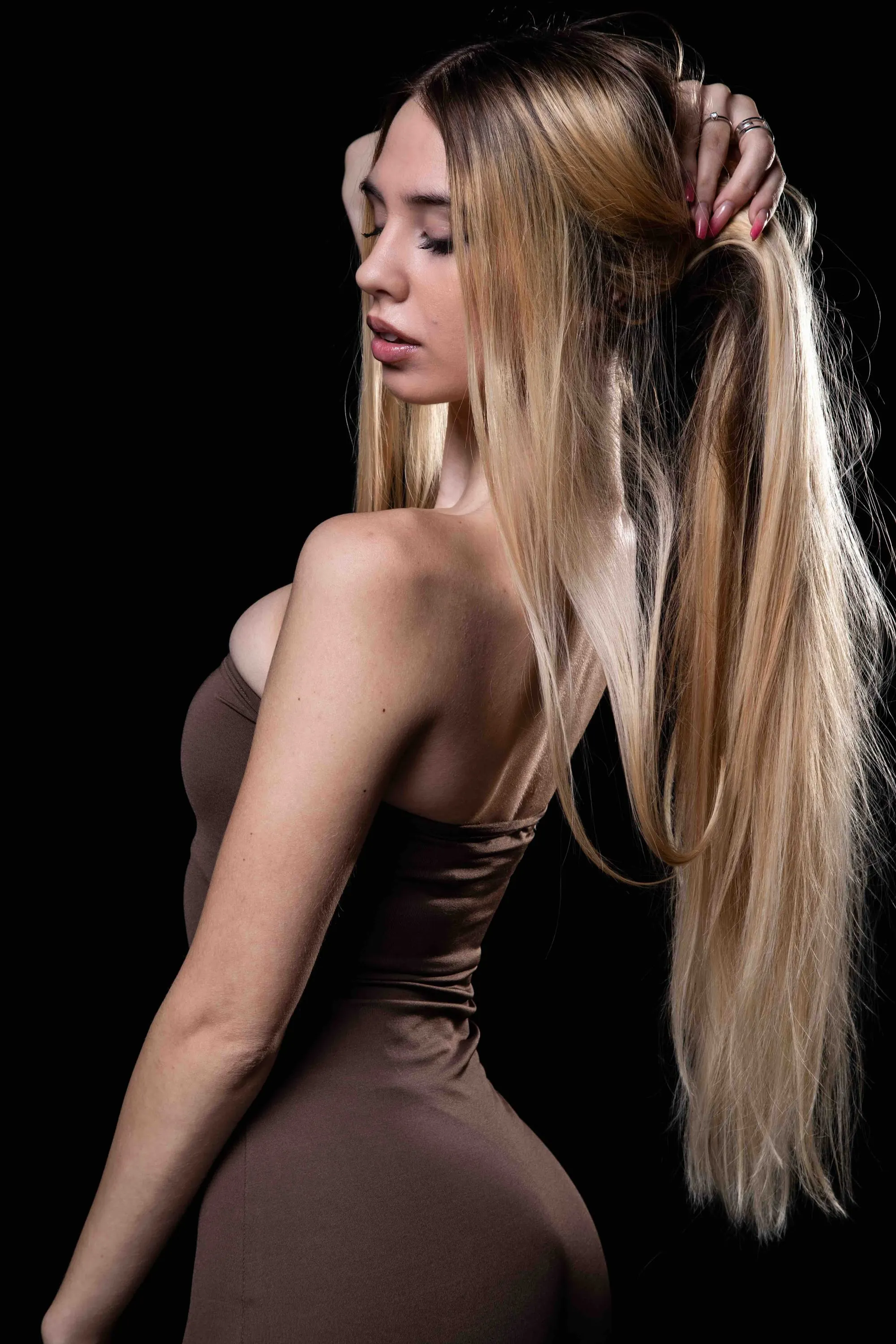 The blonde young woman, from behind, gathering her hair