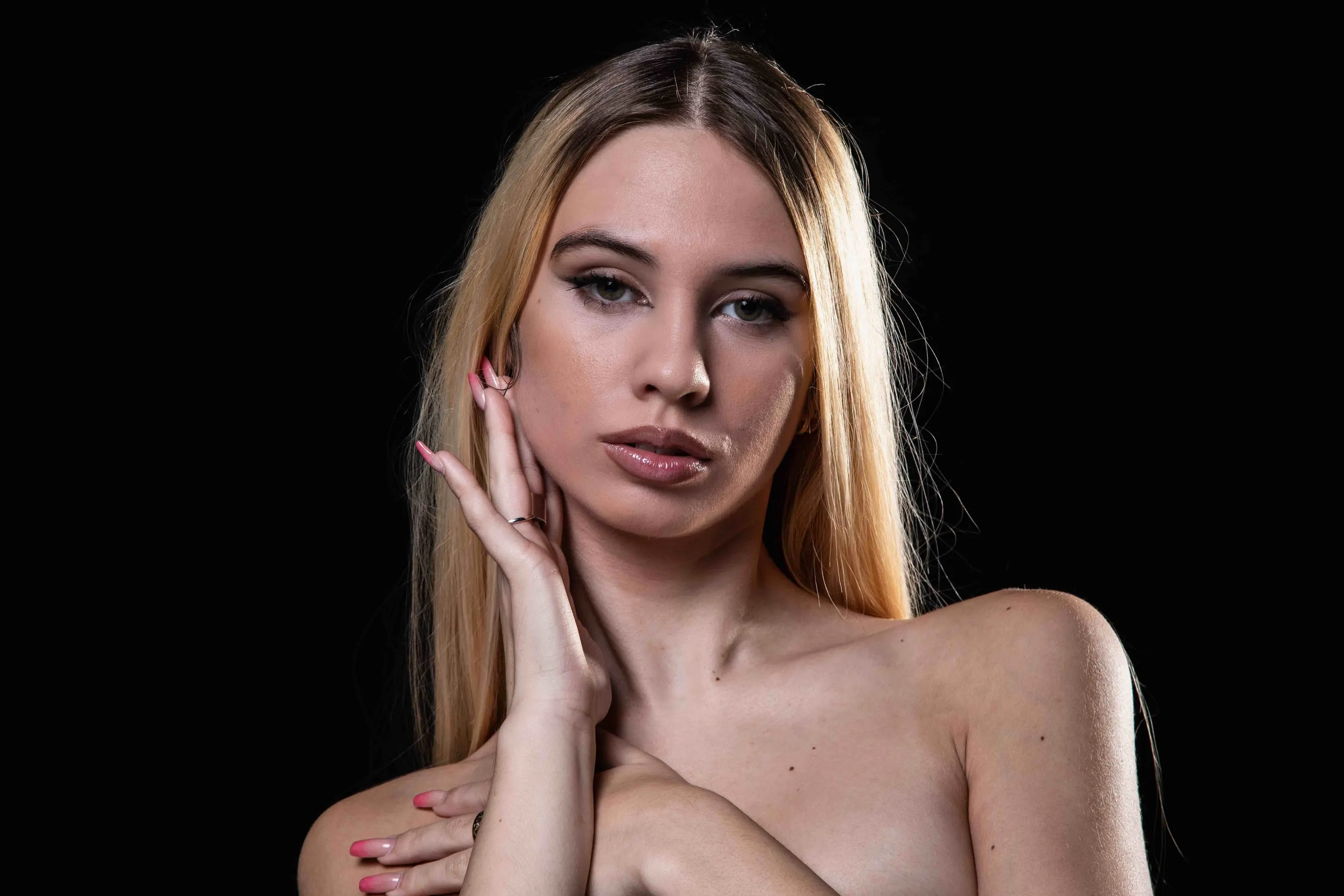 The blonde young woman with a hand to her face, horizontal frame