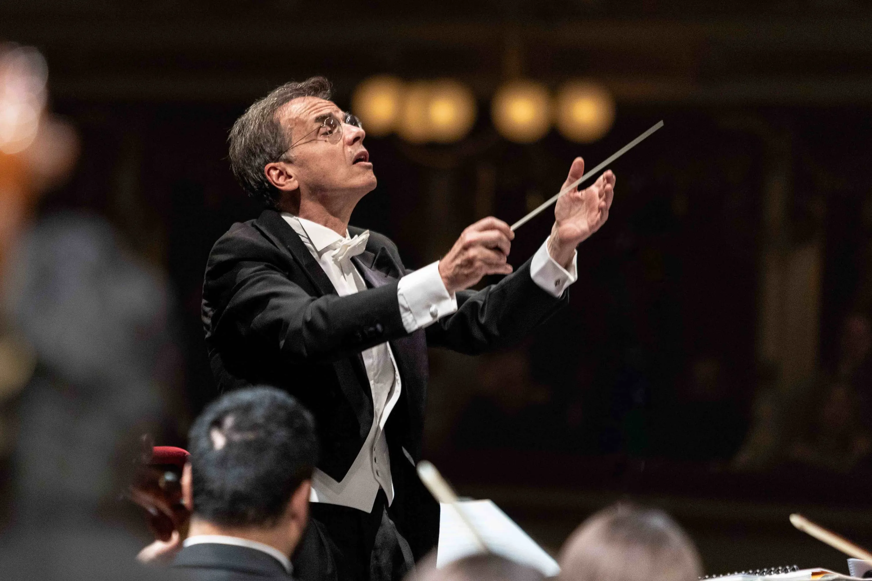 The conductor in tails leads with the baton
