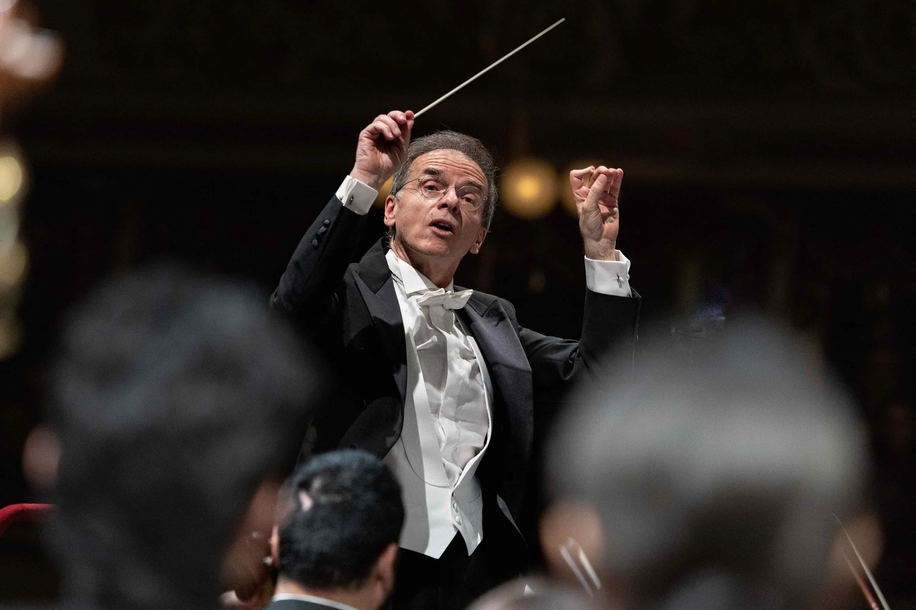The conductor with both arms raised